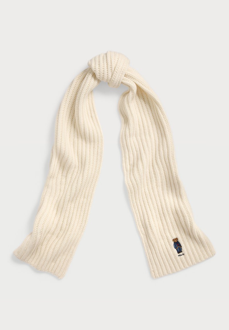 Strikket skjerf i kremfarge med ribbestruktur, med et lite brodert design av en bjørnelogo i den ene enden.