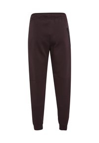 Mörkbruna joggers i mjukt tyg, med resårmidja, tapered ben och en dragkedjeficka på höger sida.