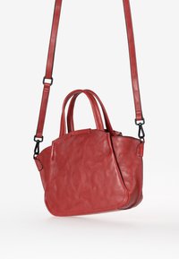 Borsa a tracolla in pelle rossa con una superficie liscia, dotata di due manici corti e una tracolla removibile. Presenta un design arrotondato e una cucitura minimale.