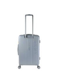 Maleta dura gris con superficie texturizada, asa retráctil y cuatro ruedas, con detalles en relieve de "DKNY" y "EST. 1989".