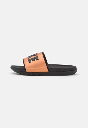 Sandale Nike noire et orange à enfiler, avec un grand logo en relief sur la sangle, une semelle intérieure texturée et une semelle légèrement surélevée.
