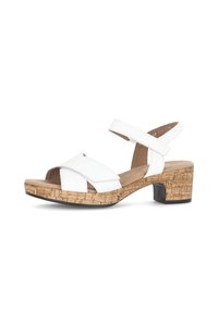 Sandal in pelle bianca con cinturini incrociati, tacco in sughero e suola in gomma. Dotata di cinturino regolabile alla caviglia per una vestibilità sicura.