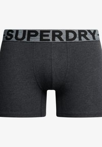 Boxer shorts gris foncé avec un waistband élastique noir et gris affichant "SUPERDRY" en lettres gras. Texture de tissu lisse, forme ajustée.