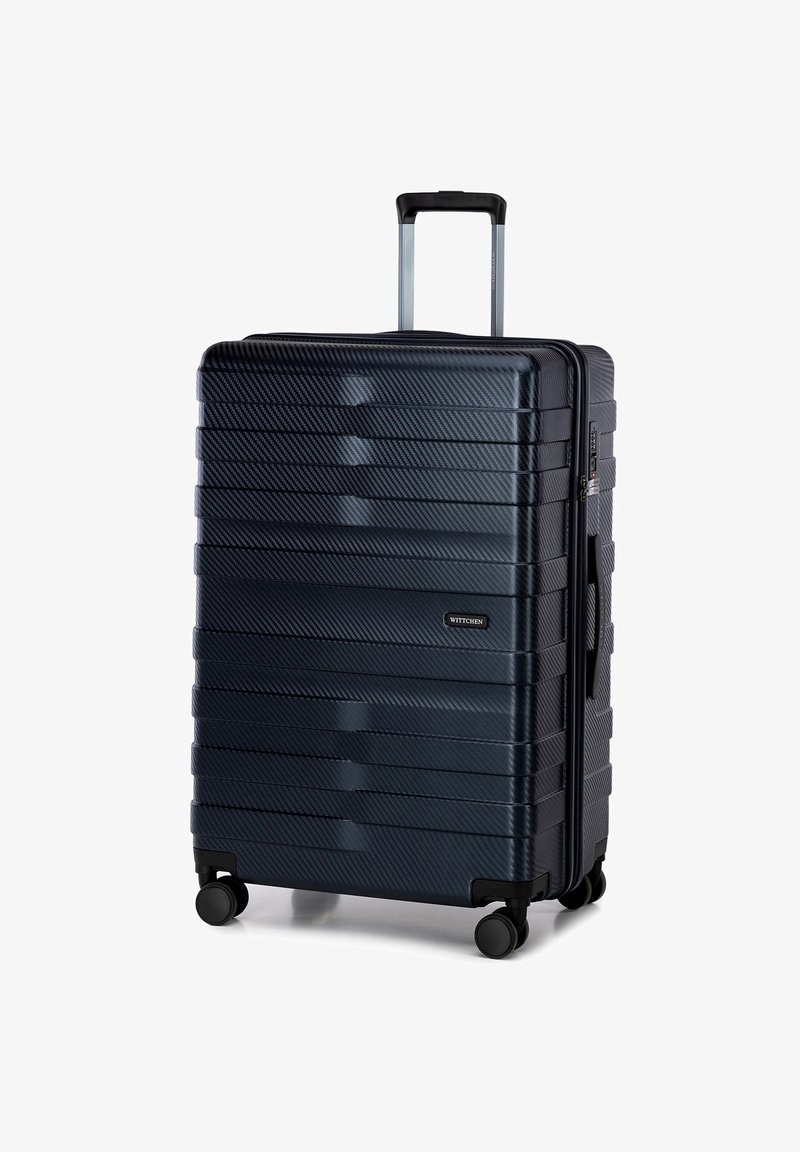 Tvrdý kufr tmavě modré barvy, se pruhovanou texturou, stříbrnou teleskopickou rukojetí a čtyřmi černými koly pro snadnou manipulaci.