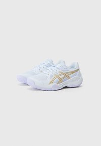 Weiße Sportschuhe mit einem Mesh-Obermaterial, goldenen Akzenten, einer gepolsterten Sohle und strukturiertem Profil für besseren Halt. Die Schnürsenkel sind auffällig auf der Zunge.