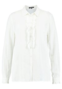 Blusa bianca a maniche lunghe realizzata in tessuto morbido, con una pattina anteriore con volant, chiusura a bottoni e polsini arricciati. Design del colletto classico.