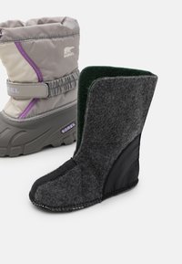 Graue isolierte Winterstiefel mit einem weichen Stoffoberteil, strukturiertem Gummisohle und einem kontrastierenden dunklen Filzbereich. Verfügt über einen Riemen und ein Logodetail.