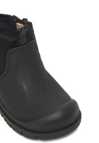 Stivaletto nero alla caviglia in pelle liscia con punta arrotondata, pannelli laterali elastici e suola in gomma testurizzata. Presenta un design minimalista.