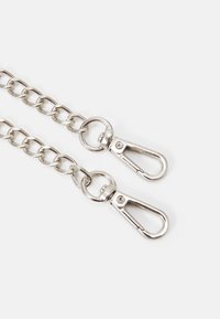 Kovový řetěz, stříbrné barvy, s dvěma pružinovými karabinami na každém konci. Má hladký povrch a jednotné kruhové články.