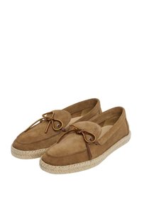Des chaussures slip-on en suède marron avec un bout arrondi, des détails en cuir et une semelle en jute de style espadrille. Design minimaliste sans motifs visibles.
