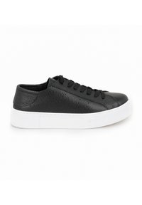 Schwarze Ledersneaker mit strukturiertem Finish, ausgestattet mit schwarzen Schnürsenkeln, einer dicken weißen Sohle und minimalen Perforationsdetails an den Seiten.