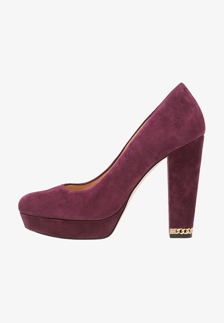 Escarpin à plateforme en daim violet avec talon bloc et détail chaîne dorée sur le bord arrière du talon.