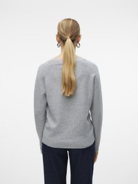 Maglione grigio a maglia con scollo rotondo, orlo a costine e maniche lunghe. Texture morbida, design aderente e dettagli di cucitura sottili sono visibili.