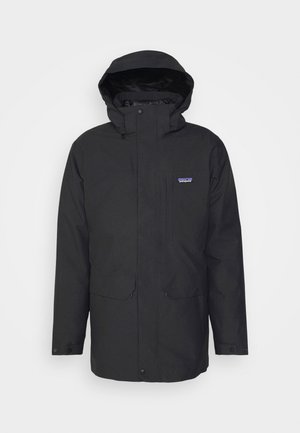 Veste noire imperméable avec capuche, fermeture éclair à l'avant, deux poches avant et un logo sur la poitrine gauche. Texture de tissu lisse, design décontracté.