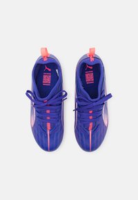 Baskets de sport violettes avec des accents roses, dotées d'une tige en mesh respirant, d'un bout rond et de lacets plats. Conçues pour le confort et la performance.