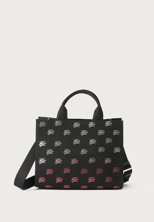 Black rectangular tote bag with short handles and a shoulder strap, decorated with repeating gradient white to pink monogram pattern.
