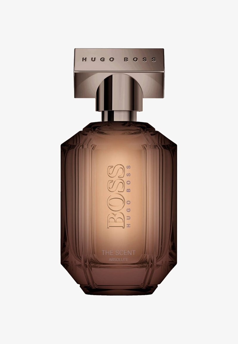 Brun glasparfymflaska med en texturerad design, försedd med en metallisk, rektangulär kork. Etiketten lyder "BOSS THE SCENT ABSOLUTE."