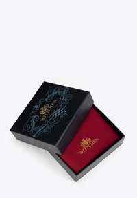 Scatola regalo nera con un elegante design blu e logo dorato, contenente un panno di stoffa rosso con bordi seghettati.