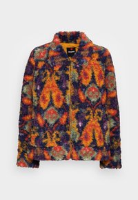 Multikleurige shaggy fleece jas met een levendig geometrisch patroon in oranje, groen en paars, met een gele binnenvoering en ritssluiting.