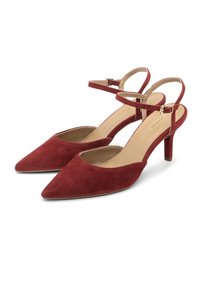 Červené semišové lodičky na podpatku se špičatou špičkou a úzkým podpatkem. Obsahují tenký pás na kotníku se sponou na zapínání. Hladké vnitřní podšívka.