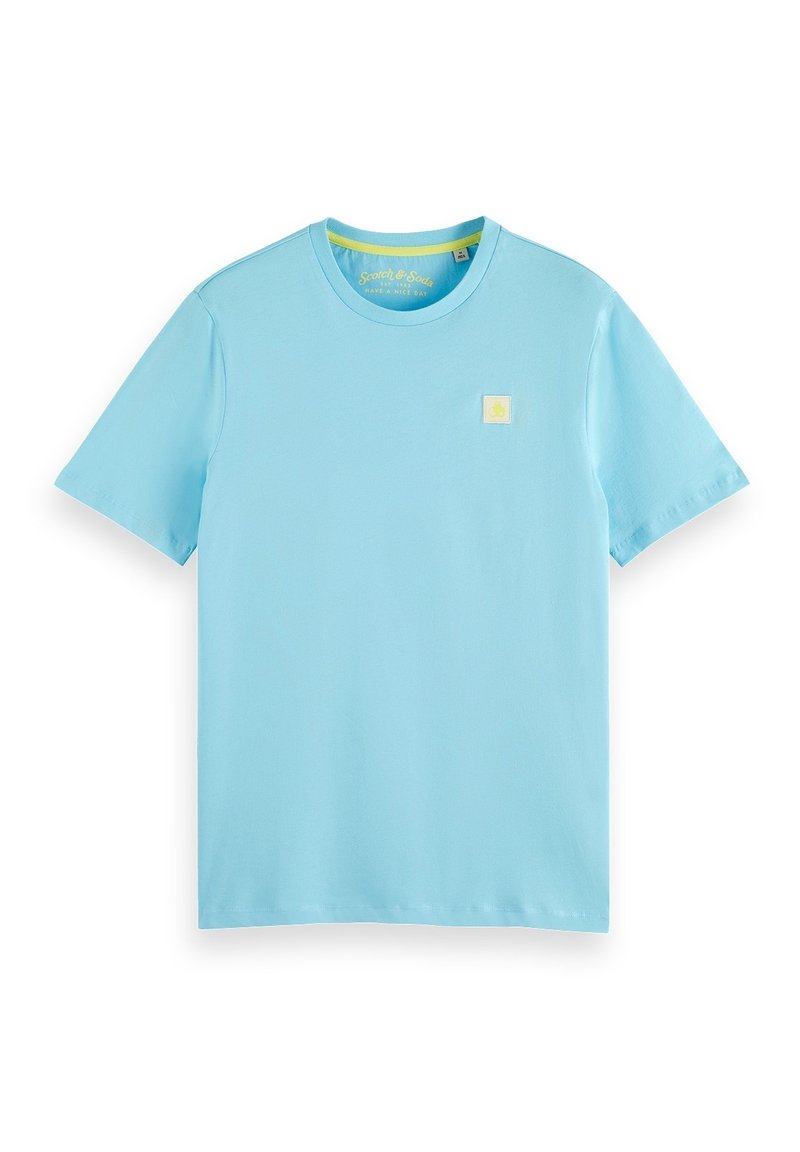 Camiseta de algodón azul claro con mangas cortas y cuello redondo. Un pequeño logo cuadrado amarillo está situado en el pecho izquierdo. Textura suave.
