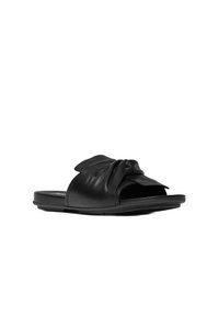 Zwarte leren slippers met een knoopaccent op de bovenkant, een gevoerd voetbed en een platte rubberen zool. Ronde vorm.