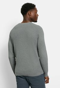 Grau meliertes Strickpullover mit langen Ärmeln und einem gerippten Ausschnitt, ausgestattet mit einem figurschmeichelnden Saum und einem lässigen Schnitt.