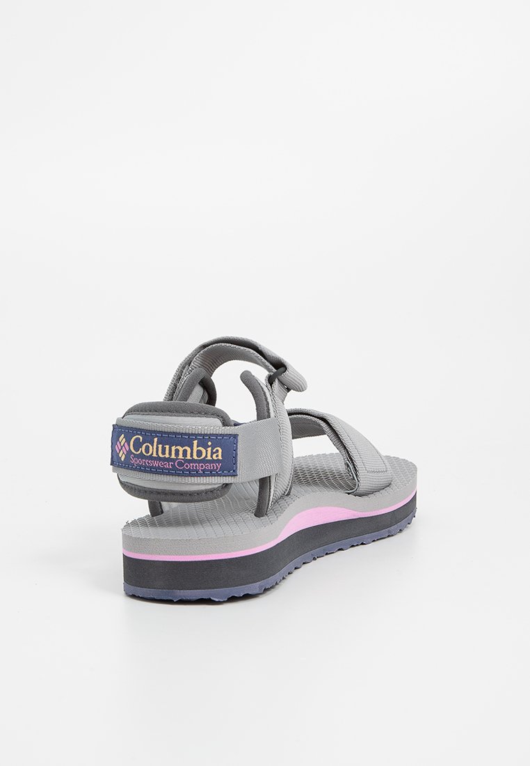Graue und rosa Columbia-Sportsandale mit verstellbaren Riemen und strukturiertem Sole, von hinten-rechts auf einem weißen Hintergrund gezeigt.