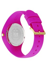Montre-bracelet en silicone rose avec un boîtier rond en métal argenté et des accents dorés. Texture lisse avec un bracelet réglable et des trous numérotés pour un ajustement de taille.