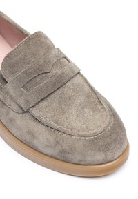 Mocassini in suede grigio tenue con una superficie liscia. Presentano una fascia decorativa e una suola in gomma marrone chiaro. Design a punta rotonda.