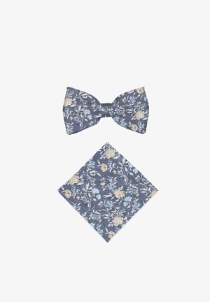 Nœud papillon bleu marine à motif floral et pochette assortie avec des fleurs beige et bleu clair ainsi que des motifs feuillus sur fond blanc.