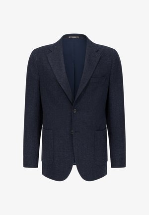 Blazer en chevrons bleu marine avec revers à cran, deux boutons et poches à rabat. L'intérieur présente une doublure lisse de couleur foncée. Matériau en laine mélangée texturée.