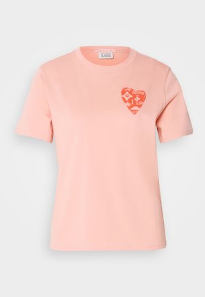 Kortärmad rosa bomullströja med ett hjärta i grafik på bröstet och detaljerade mönster. Klassisk rund halsringning och standardpassform.