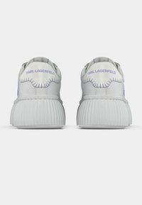 Λευκά αθλητικά παπούτσια με ραβδωτή σόλα και ανοιχτό μωβ ραφές. Διαθέτουν εμφανές λογότυπο στην φτέρνα και υφασμάτινο σχεδιασμό στο πάνω μέρος.