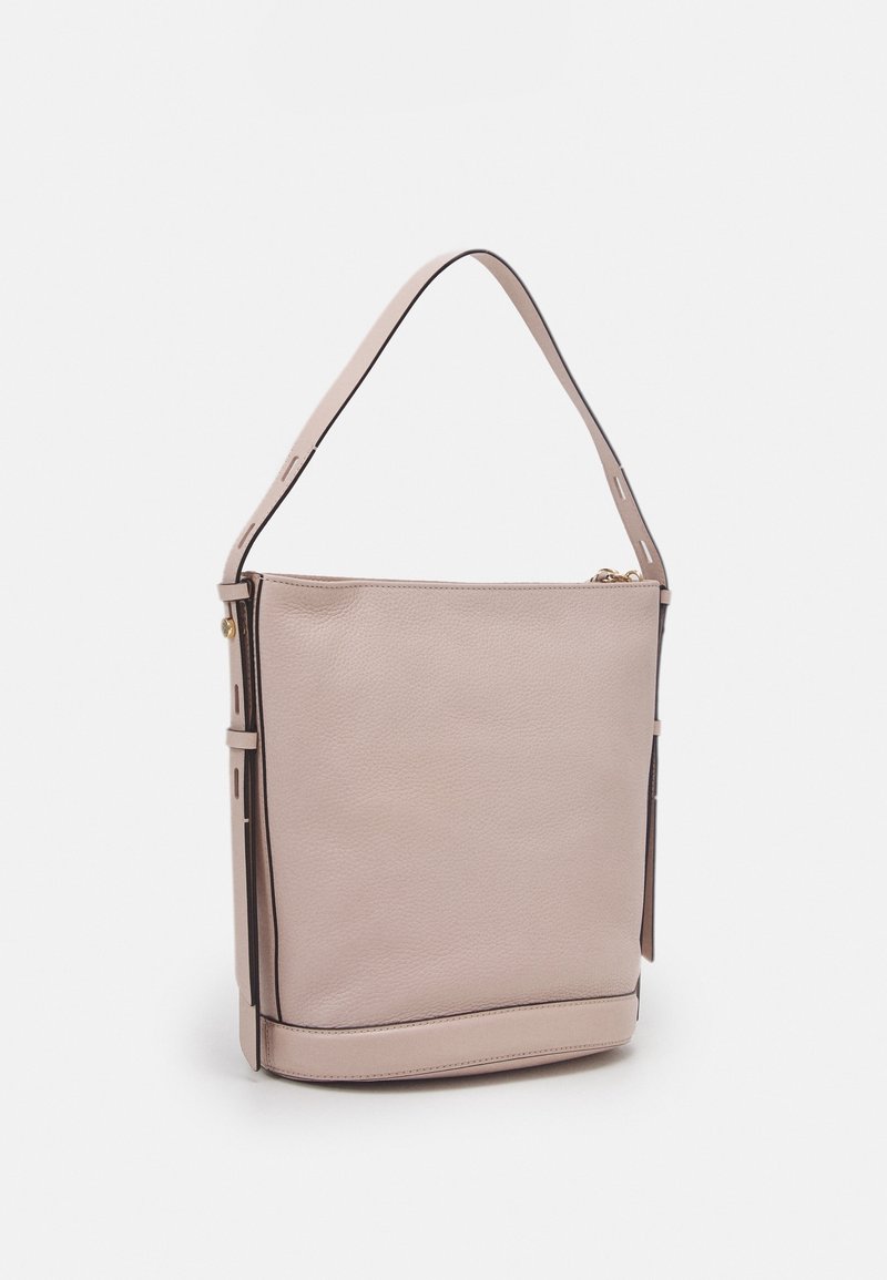 Sac à épaule en cuir beige avec une sangle unique, forme rectangulaire et détails de couture subtils sur un fond uni.