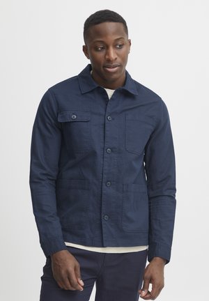 Navy blue jacket with a collar, front button closure, chest and side pockets, and long sleeves. Made from textured fabric.