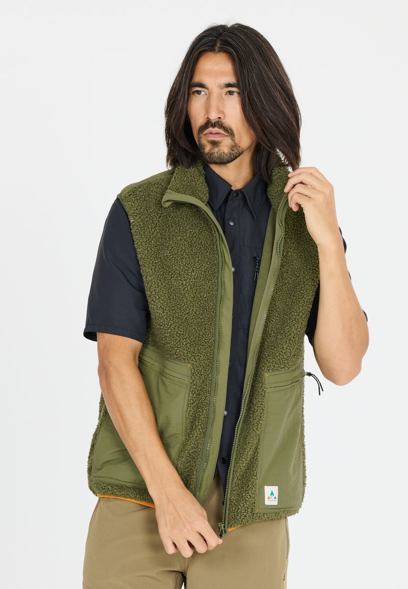 Groene vest met fleece voering, gemaakt van een gladde stof, met ritssluiting en twee voorke pockets. Beschikt over een logo in de linkerbenedenhoek.