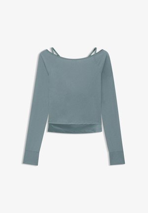 Haut à manches longues bleu gris subtil avec encolure bateau, bretelles intérieures visibles et détail de ourlet à couches.