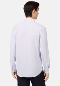 Camicia a maniche lunghe di un leggero colore viola con un delicato motivo a quadri, orlo curvo e polsini abbottonati, realizzata in un tessuto liscio.