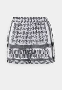 Černobílé šortky s vzorem a elastickým pasem, s designem štvanice a cik-cak, vyrobené z lehkého materiálu.