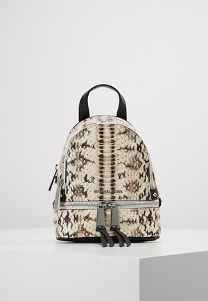 Petit sac à dos avec motif imprimé serpent, présentant des tons beige et marron, des accents noirs et des ferrures en argent. Fermeture à glissière et double bretelles.