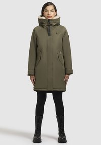 Olijfgroene parka met een zachte binnenvoering, hoge kraag, rits aan de voorkant en twee zijzakken. Ontworpen voor warmte met een knielange pasvorm.