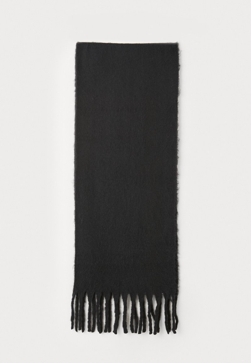 Écharpe noire en matériau doux et texturé. Présente des bords à franges avec une forme rectangulaire.