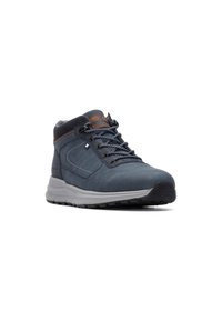 Zapato de senderismo mid-top para hombre en material sintético azul oscuro, con un acento en cuero marrón, superficie texturizada y suela de goma negra.