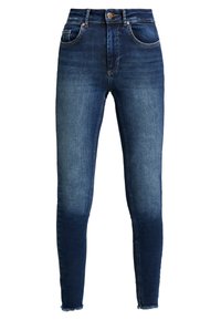 Vaqueros ajustados de cintura alta en azul oscuro, confeccionados en denim. Presentan un desvanecimiento a lo largo de las piernas y un dobladillo deshilachado. Diseño clásico de cinco bolsillos con herrajes metálicos.