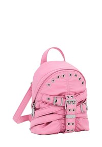 Mały różowy plecak z metalowymi oczkami, wieloma dekoracyjnymi paskami i uchwytem na górze na tle białym.