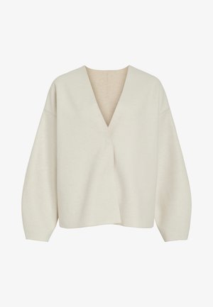 Kreminės spalvos užlenkta megztinis su giliu V formos iškirpimu, laisvu siluetu ir žemomis pečių siūlėmis. Minkšta, tekstūruota medžiaga be matomų užsegimų ar raštų.