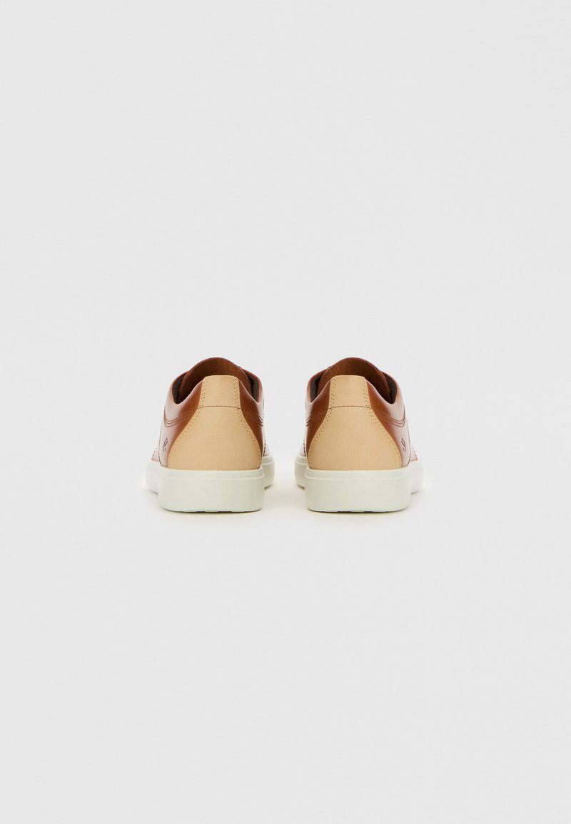 Braune Leder-Sneaker mit einem beigen Lederelement, ausgestattet mit einer weißen Gummisohle und einer glatten Textur, von hinten betrachtet.