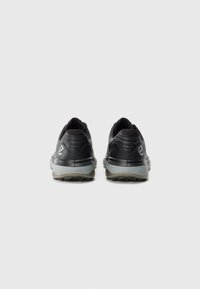 Pair of black athletic shoes shown from the back with gray soles and a white logo on the heel against a white background.