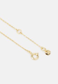 Guldhalsband med en fin länkdesign, en rund snäpplås och en liten logocharm i ena änden.